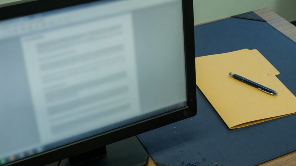 Credit Scores on a Charged-Off Tape: What a Bid Can Use 1 A blurred monitor beside a closed folder and a pen, with no account data readable