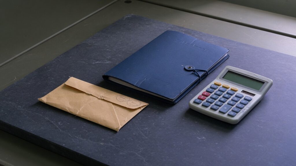 Payday and Small-Dollar Charge-Offs: The Tape a Buyer Needs 1 A small sealed envelope, a closed folder, and a calculator with the display off